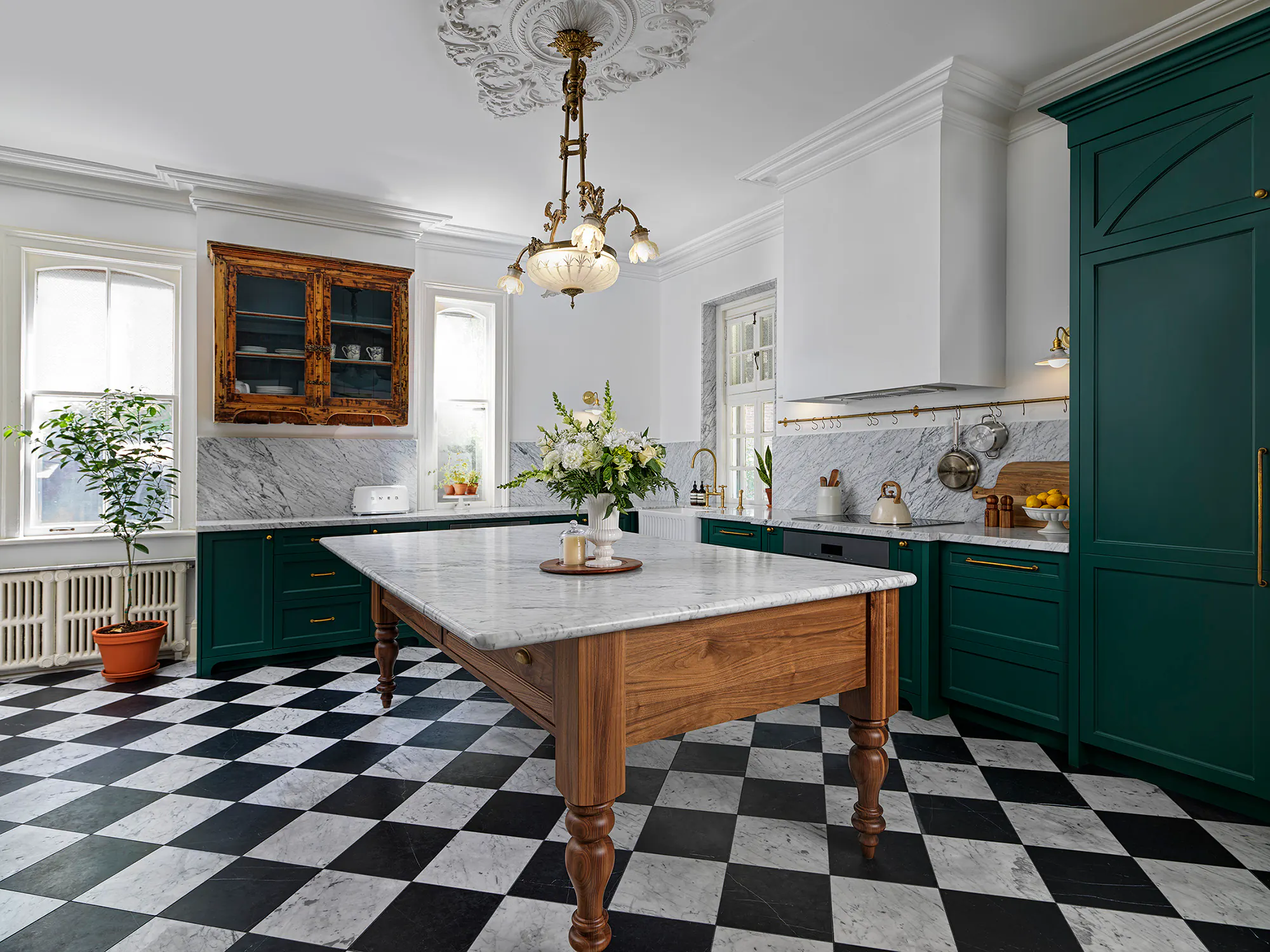 Heritage kitchen with deep green painted cabinetry, a walnut furniture-style island and a checkerboard marble floor