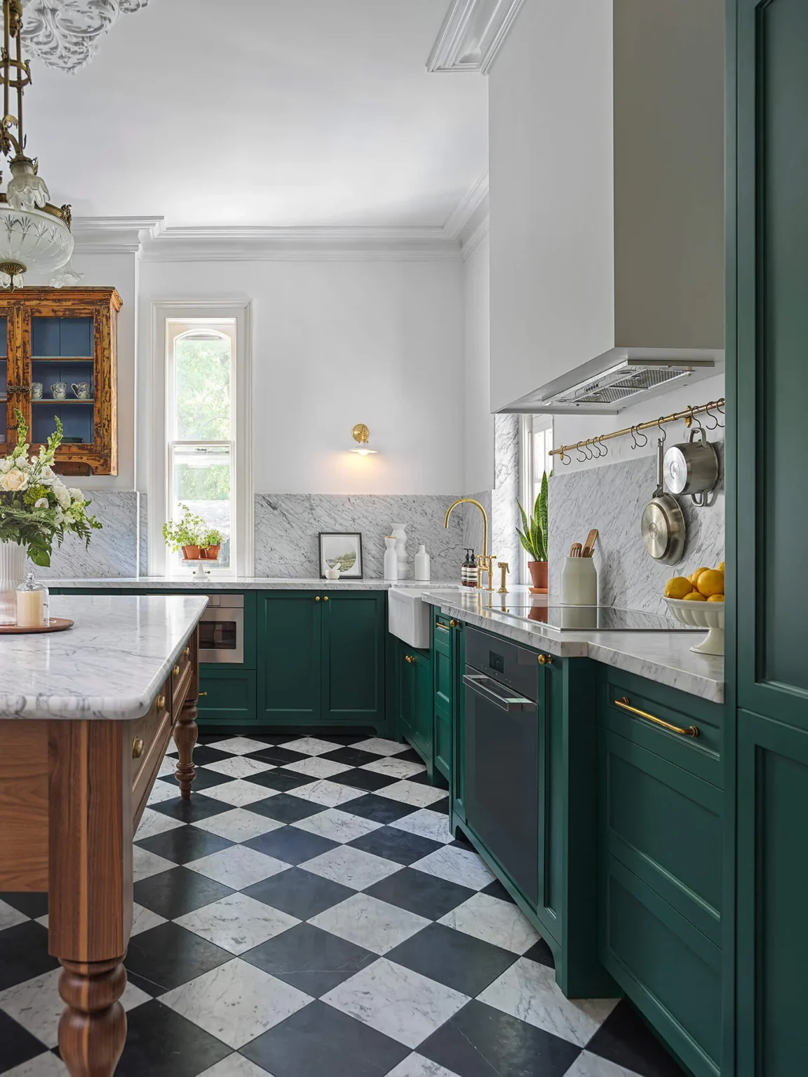 View along the green cabinetry toward the walnut island and windows