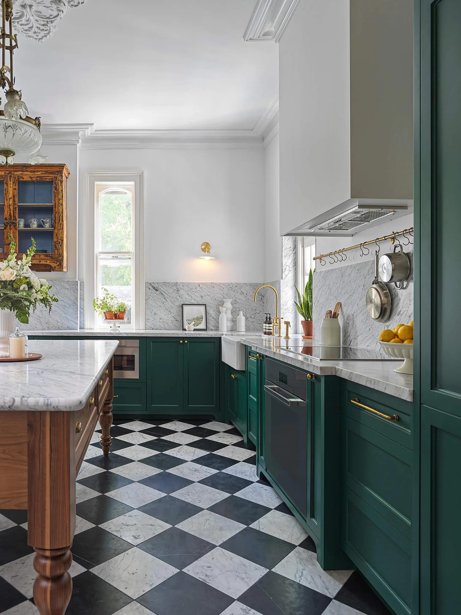 View along the green cabinetry toward the walnut island and windows