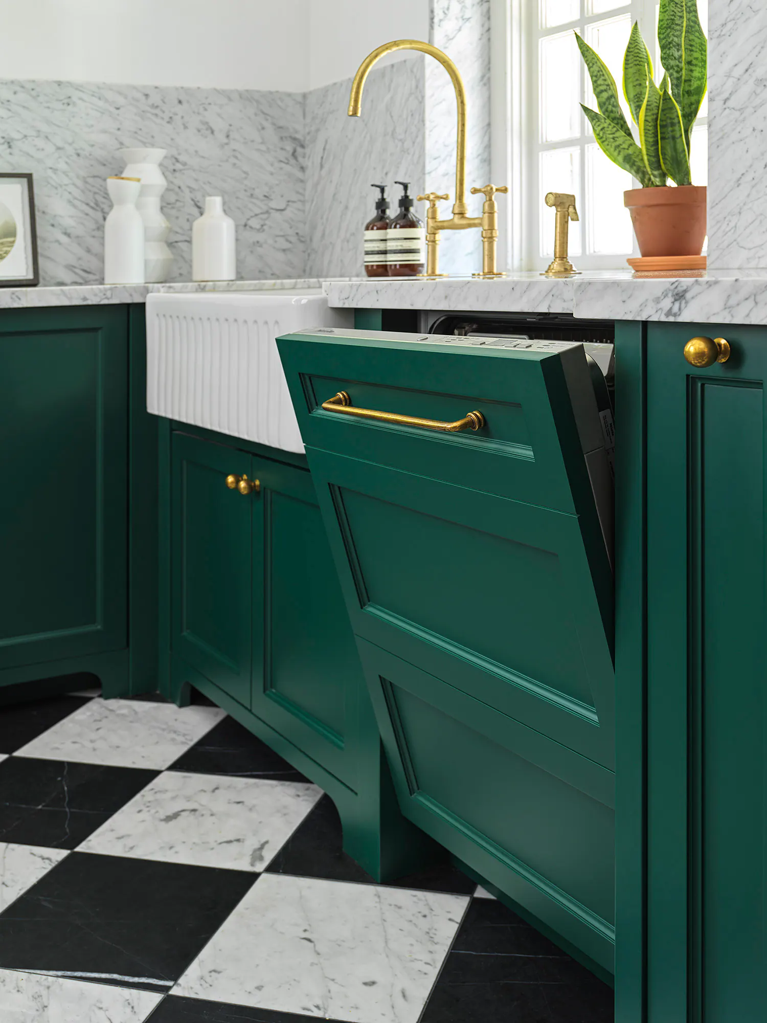 Fluted apron-front sink and brass faucet set in green painted cabinetry