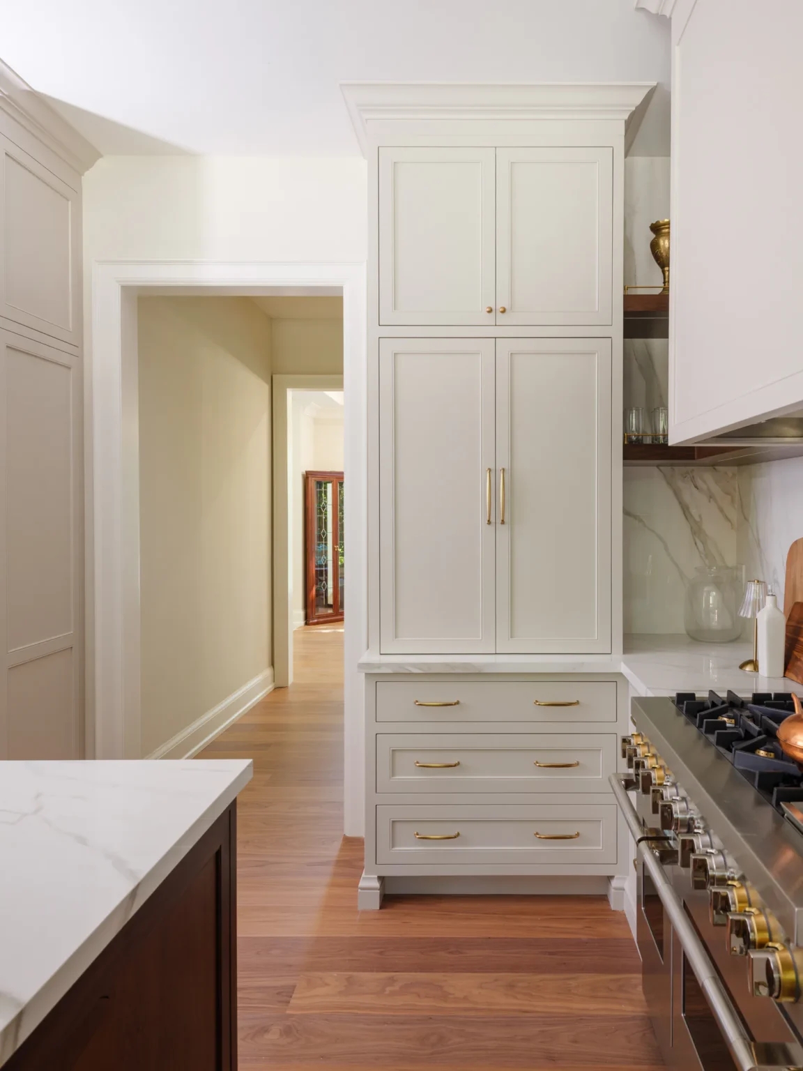 Tall painted cabinetry beside the range