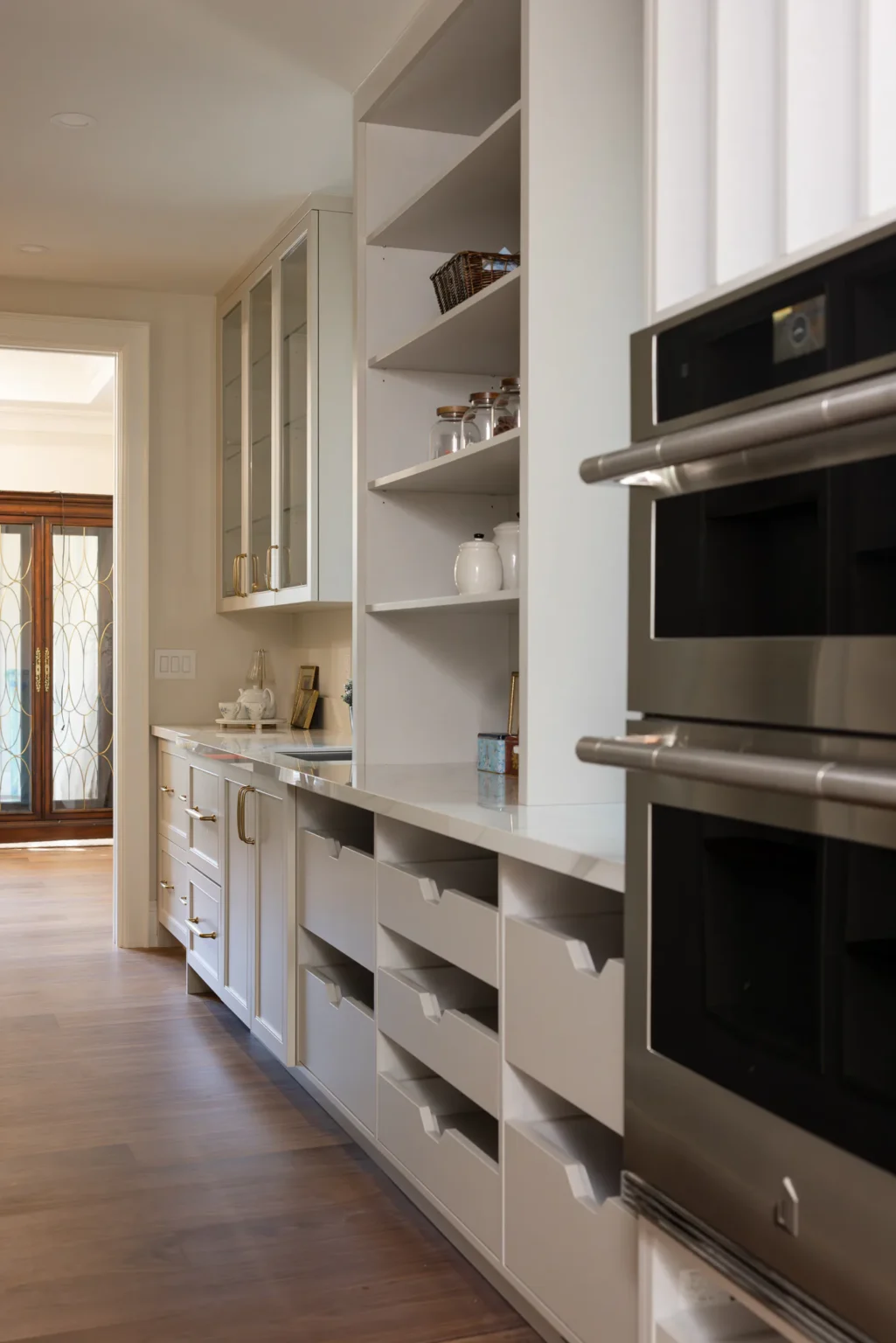 Pantry shelving beside built-in wall ovens