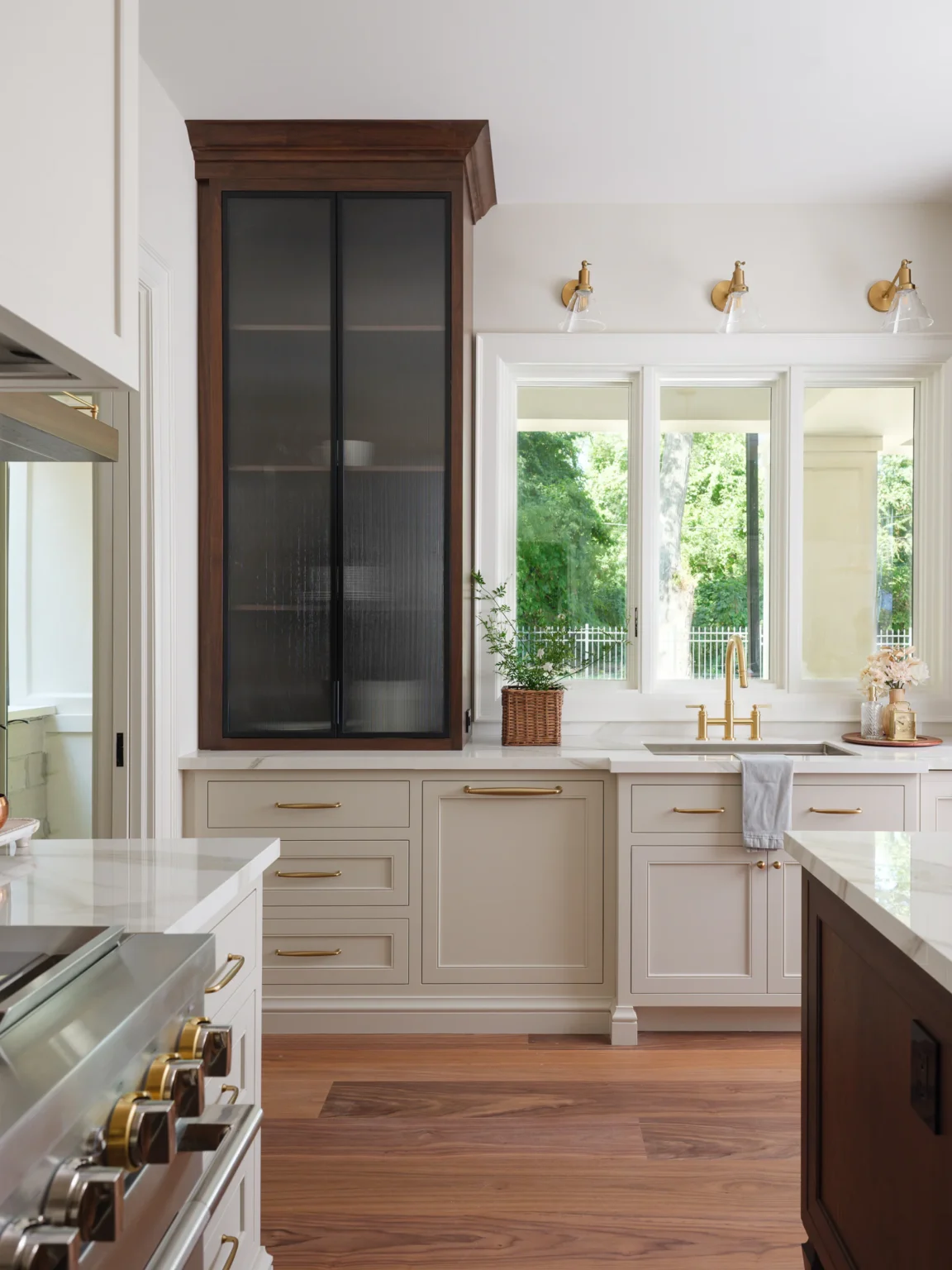 Sink wall with painted framed inset cabinetry and a walnut hutch