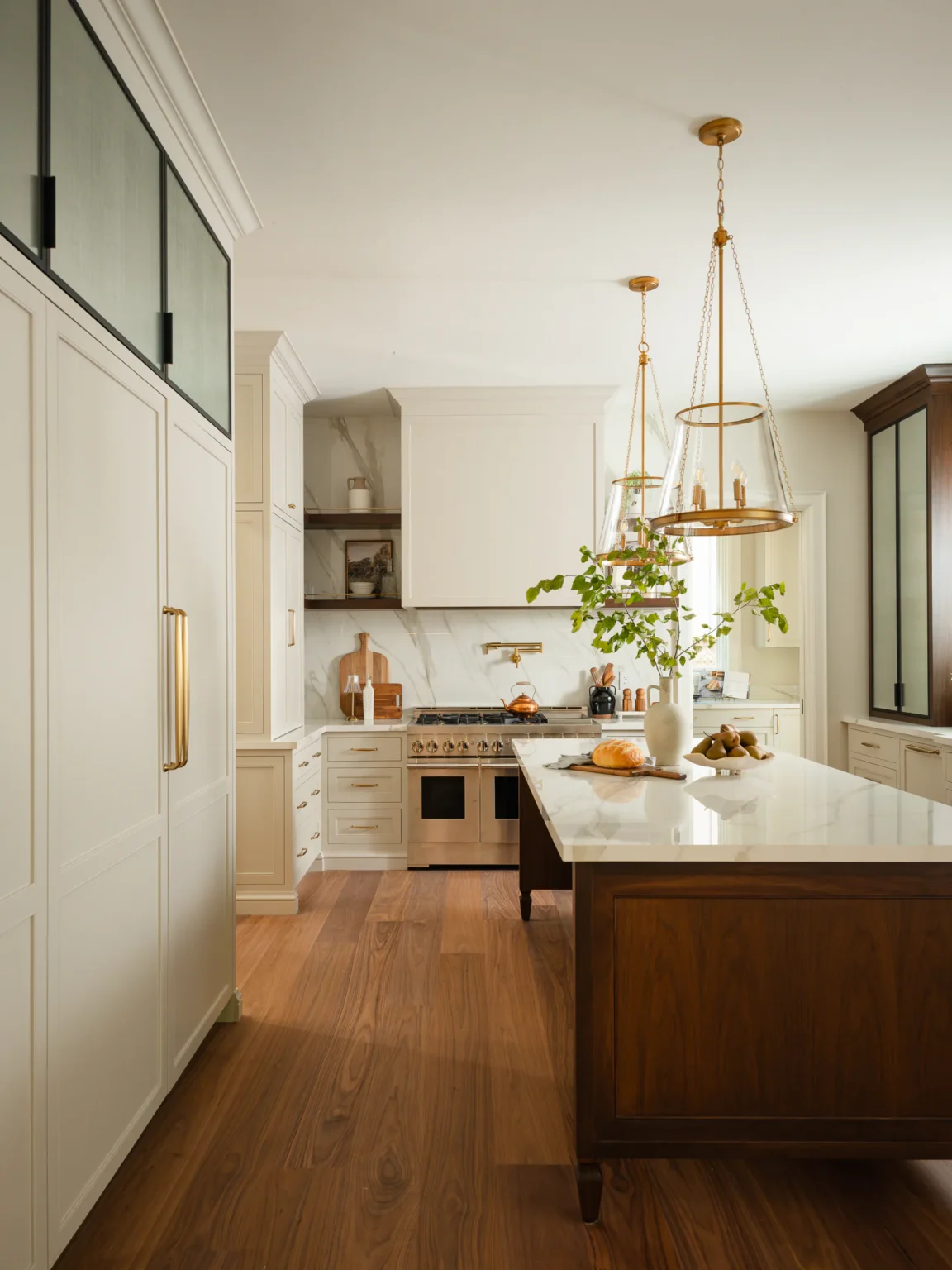 Painted framed inset cabinetry with a panelled refrigerator and the walnut island