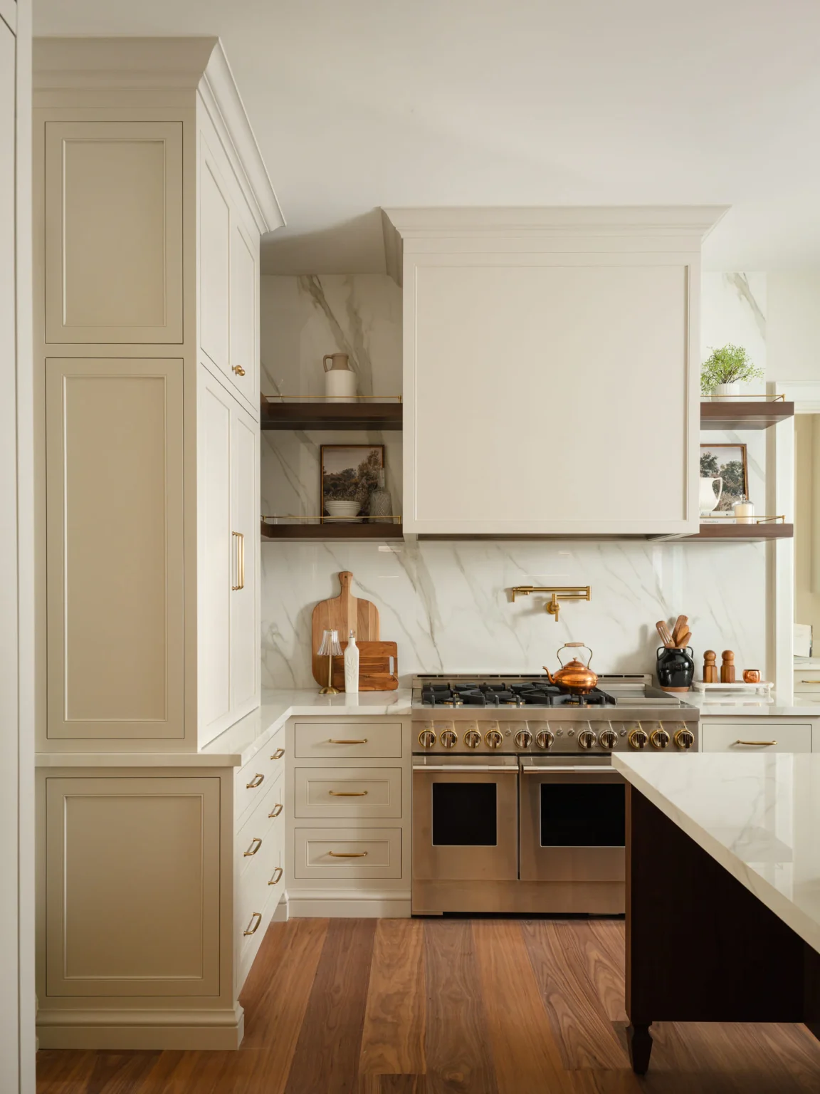 Range wall with painted cabinetry and walnut floating shelves