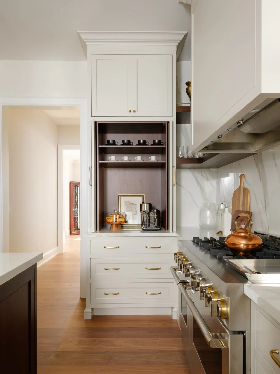 Painted cabinetry with walnut details beside the range