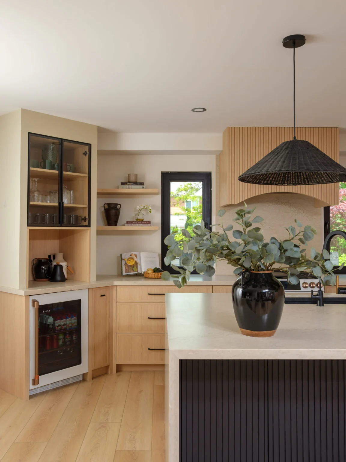Glass-front display cabinet, open shelving and custom range hood in an Oakville kitchen
