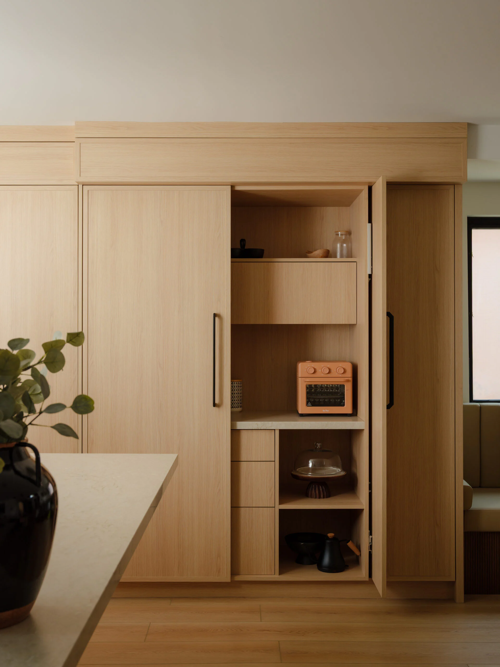 Large pocket doors open on tall custom cabinetry, revealing an interior work area