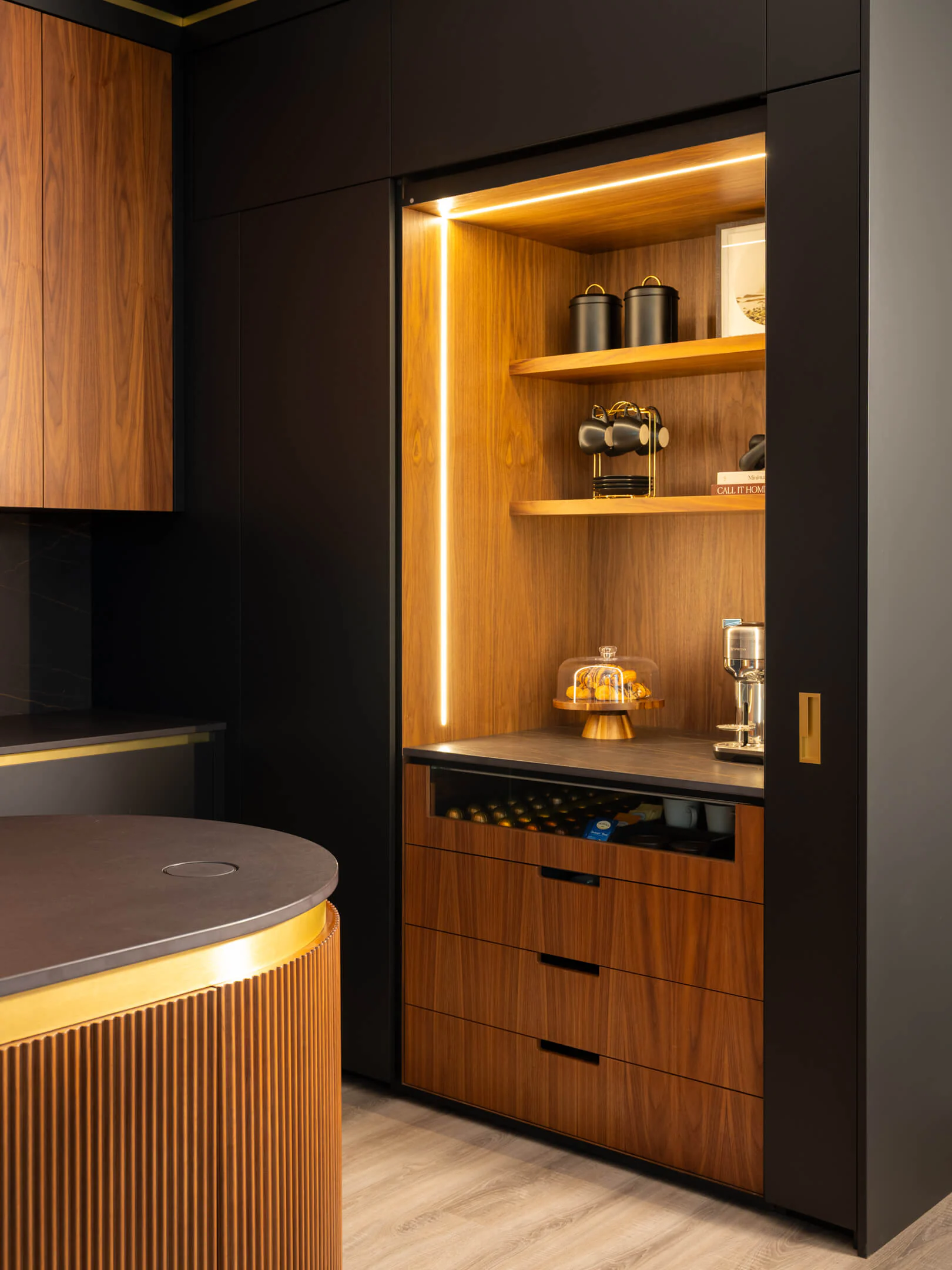 Coffee bar with pocket doors open, revealing a lit walnut interior