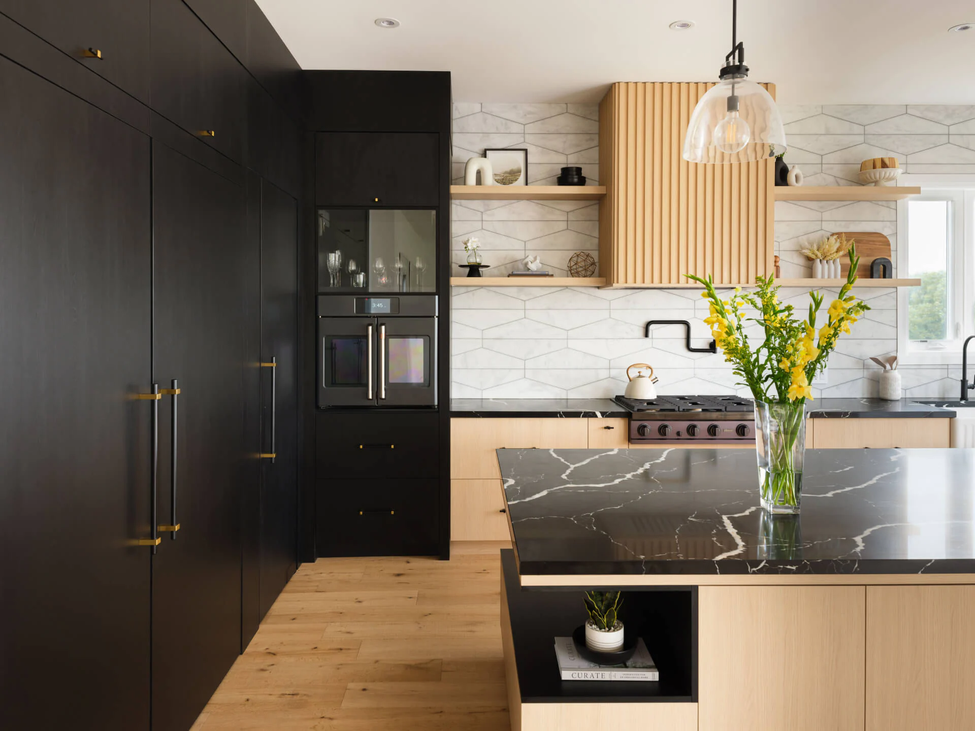 Dark full-height cabinetry and island with a black stone countertop