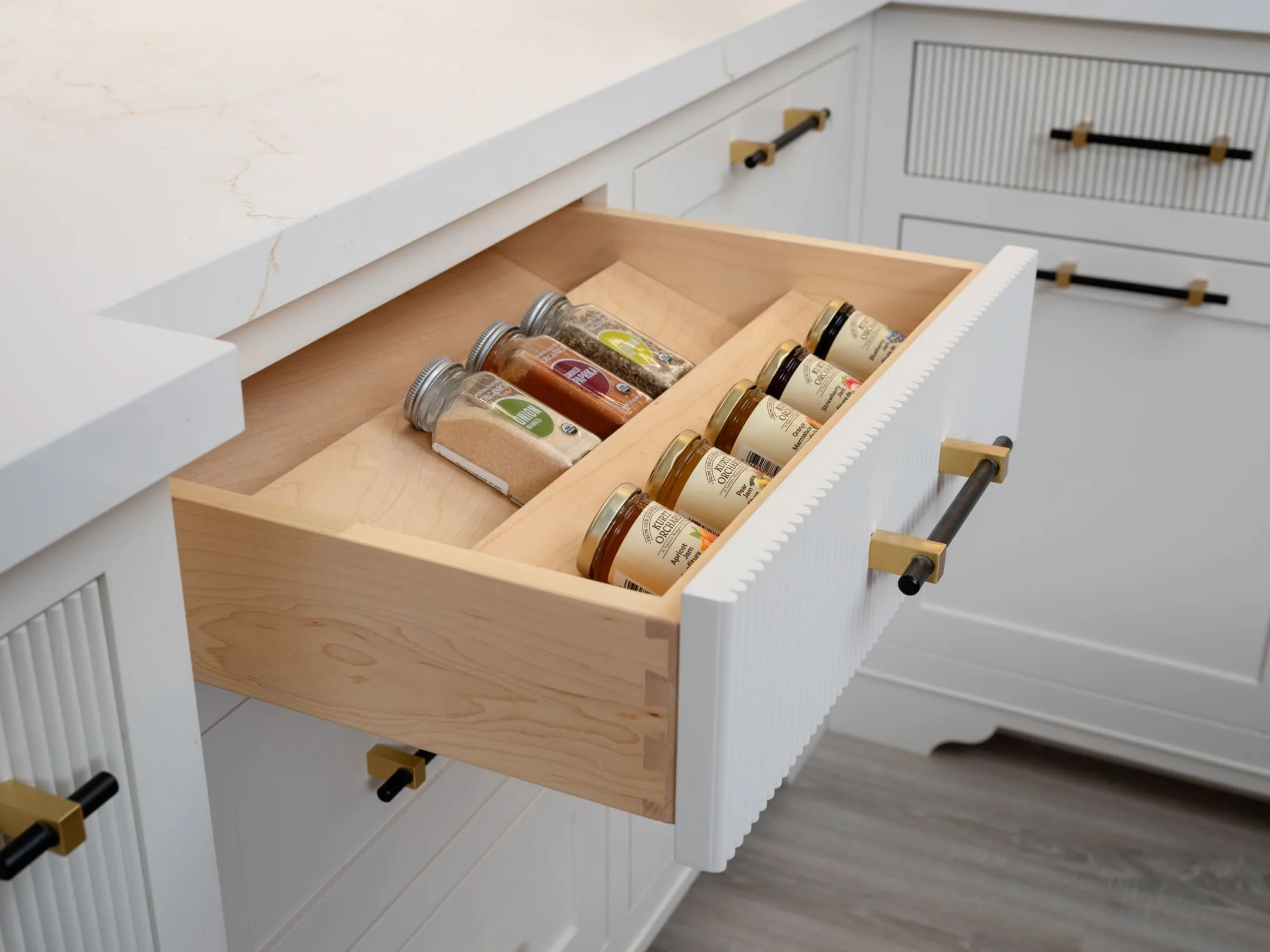 Open drawer with a custom wood insert in painted cabinetry
