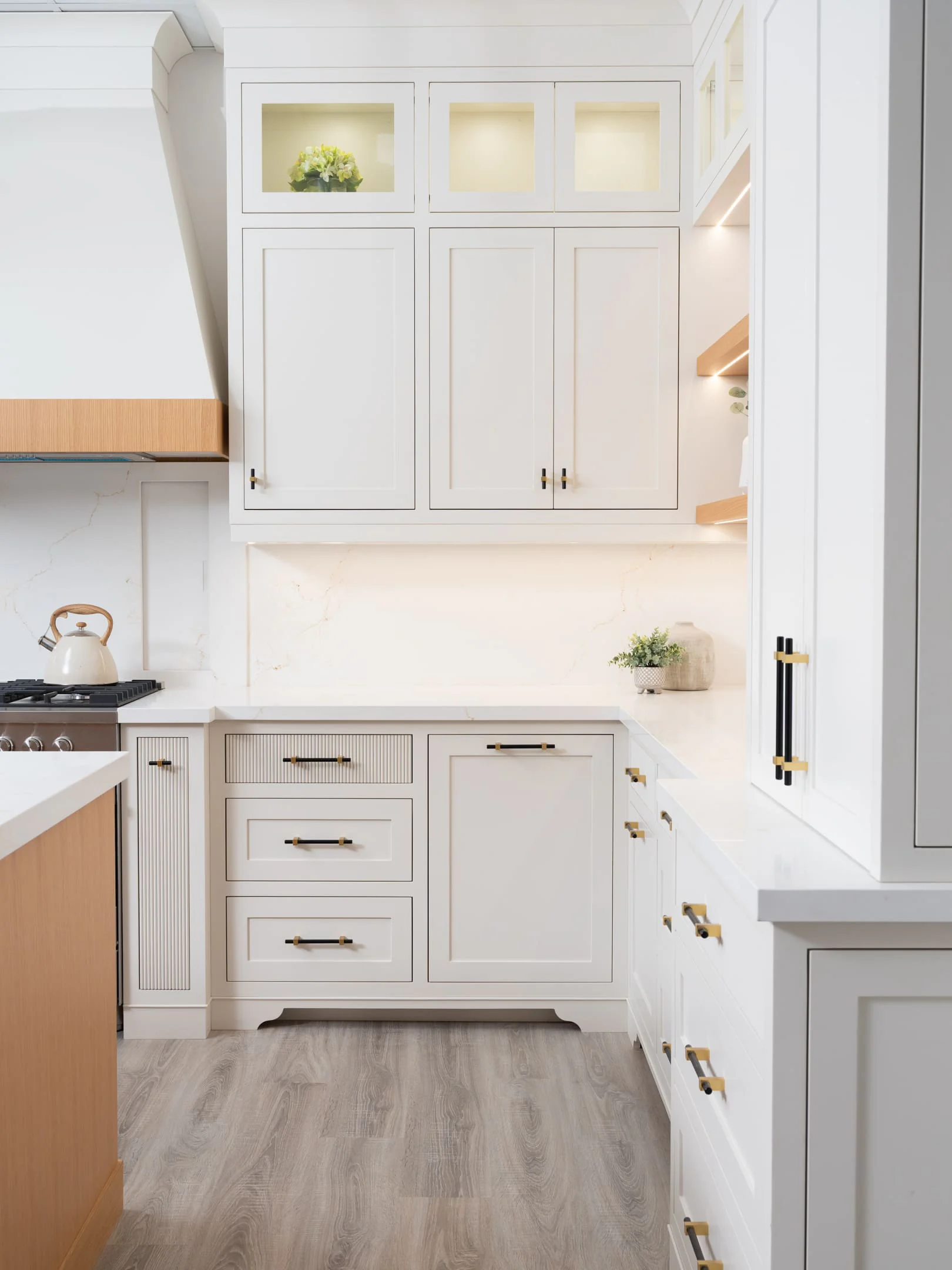 Painted perimeter cabinetry beside the white oak island