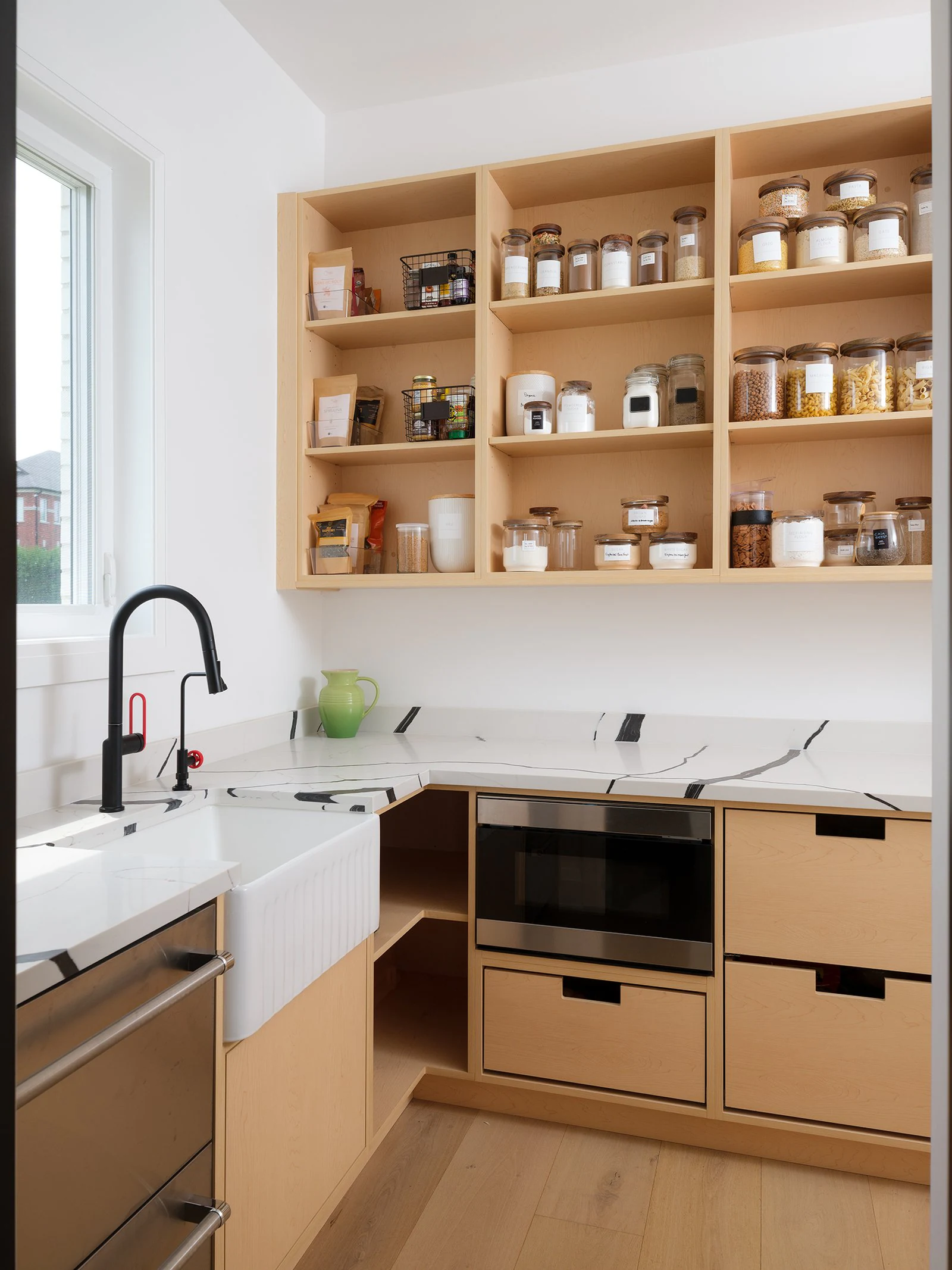 Working pantry with wood cabinetry, open shelving, a sink and storage drawers