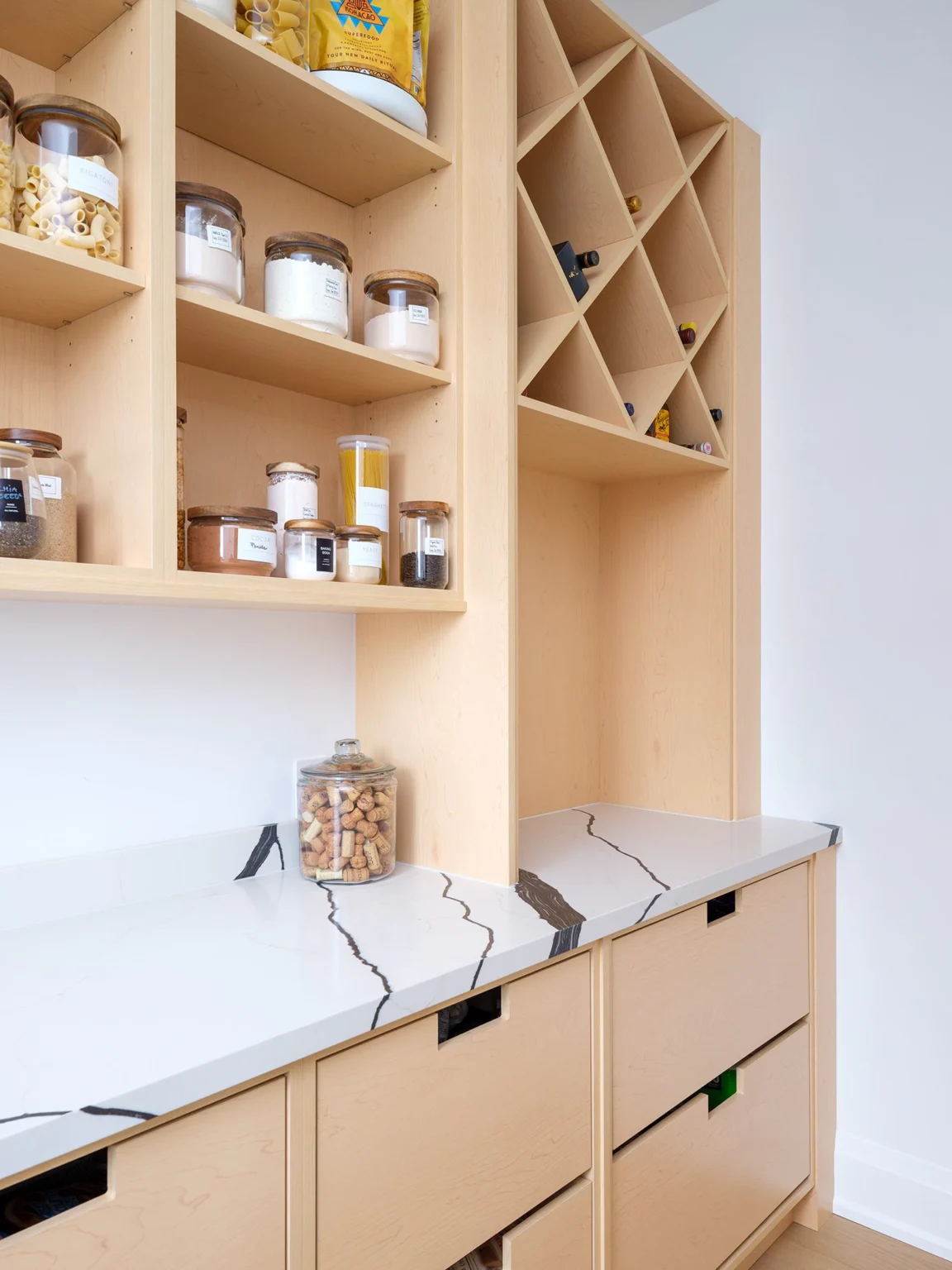 Working pantry with open wood shelving, storage drawers and a diagonal bottle rack