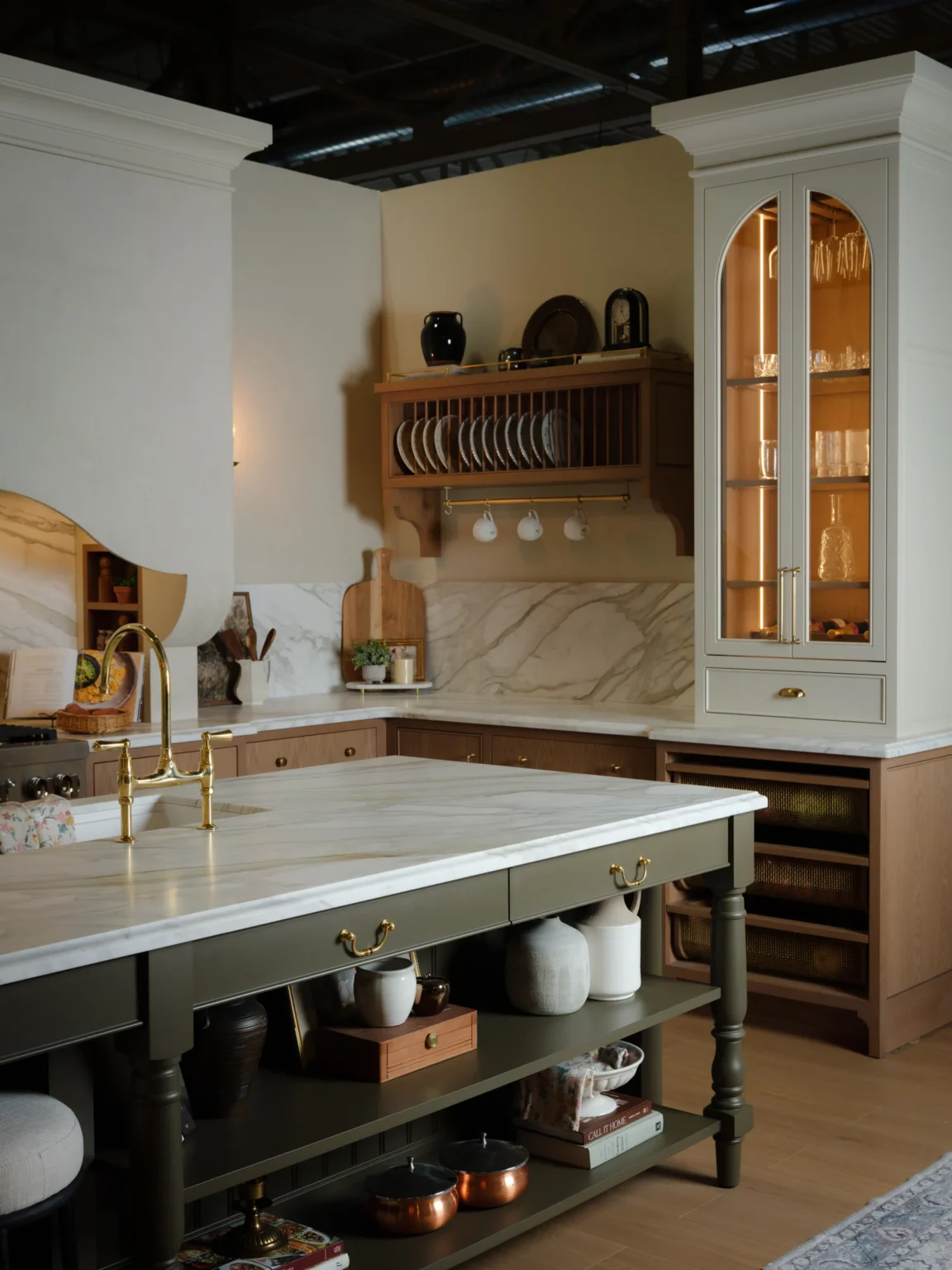 Venetian plaster range hood beside the arched hutch and plate rack