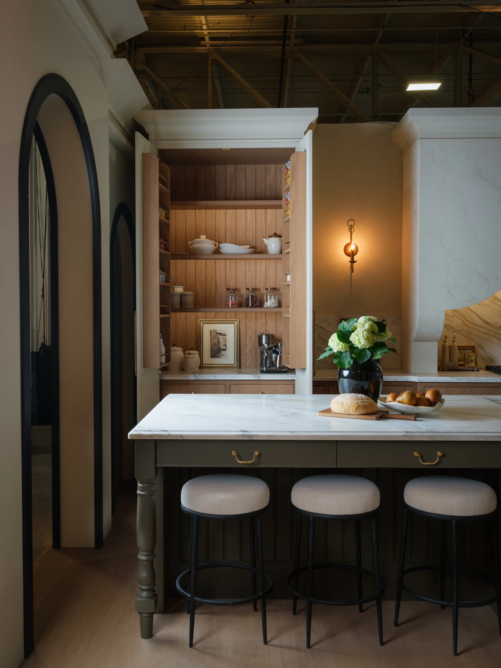 Coffee bar and pantry with doors open, revealing lit shelving and custom inserts